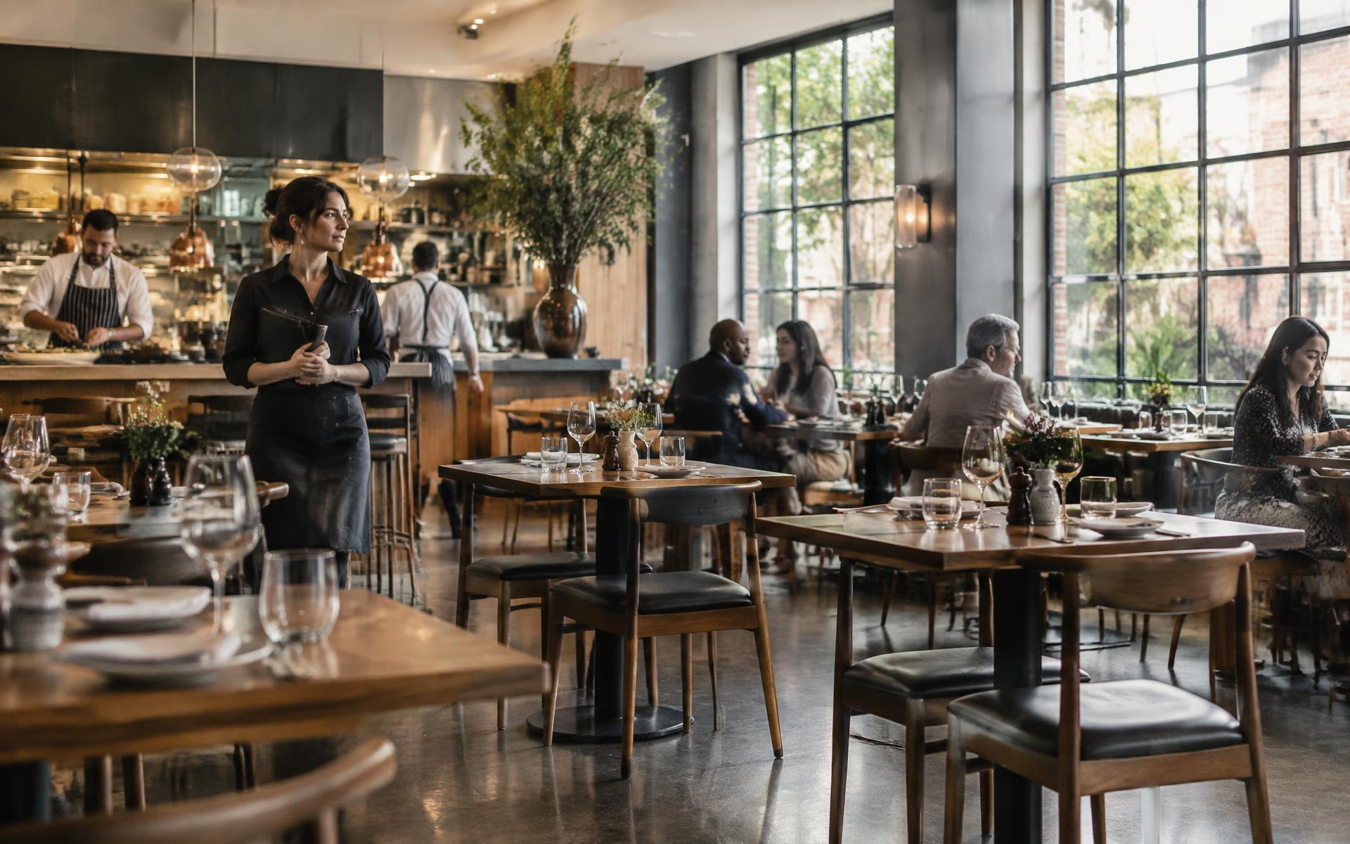 Restaurant manager considering a dining room with a mix of occupied and available tables between busy periods.
